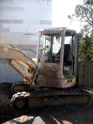 mud covered excavator after rock cutting with diamond rocksaw